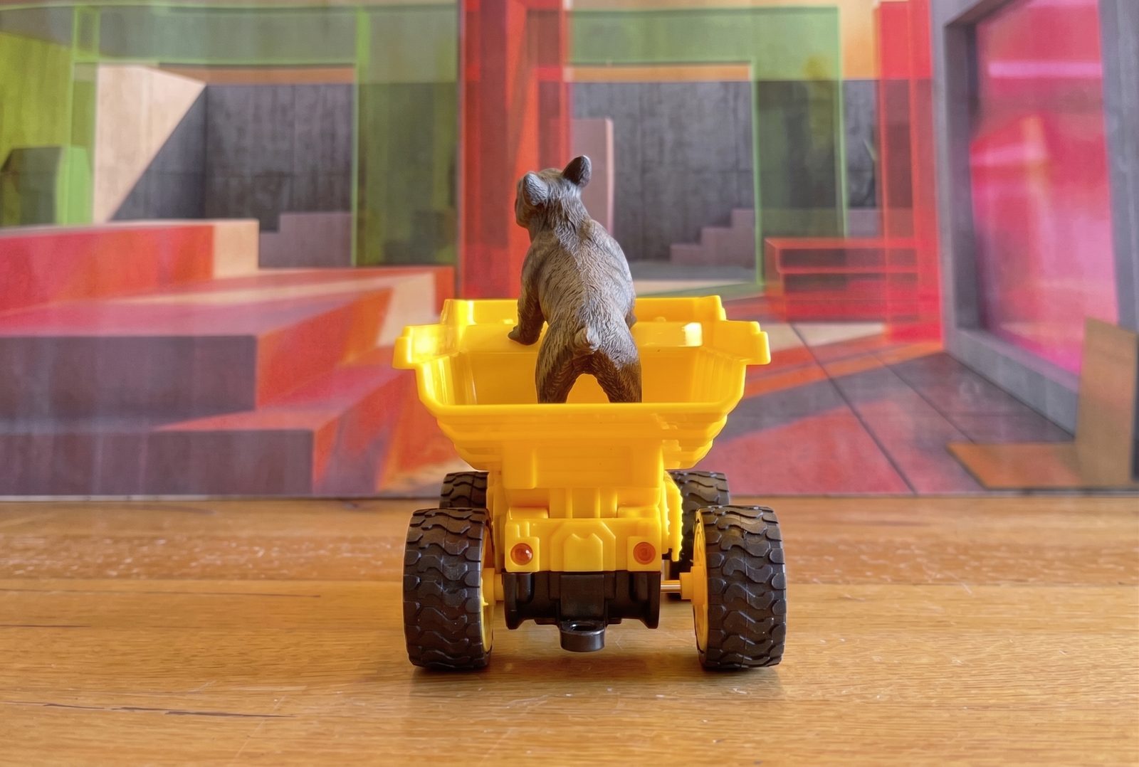 Toy bear standing in a yellow dump truck