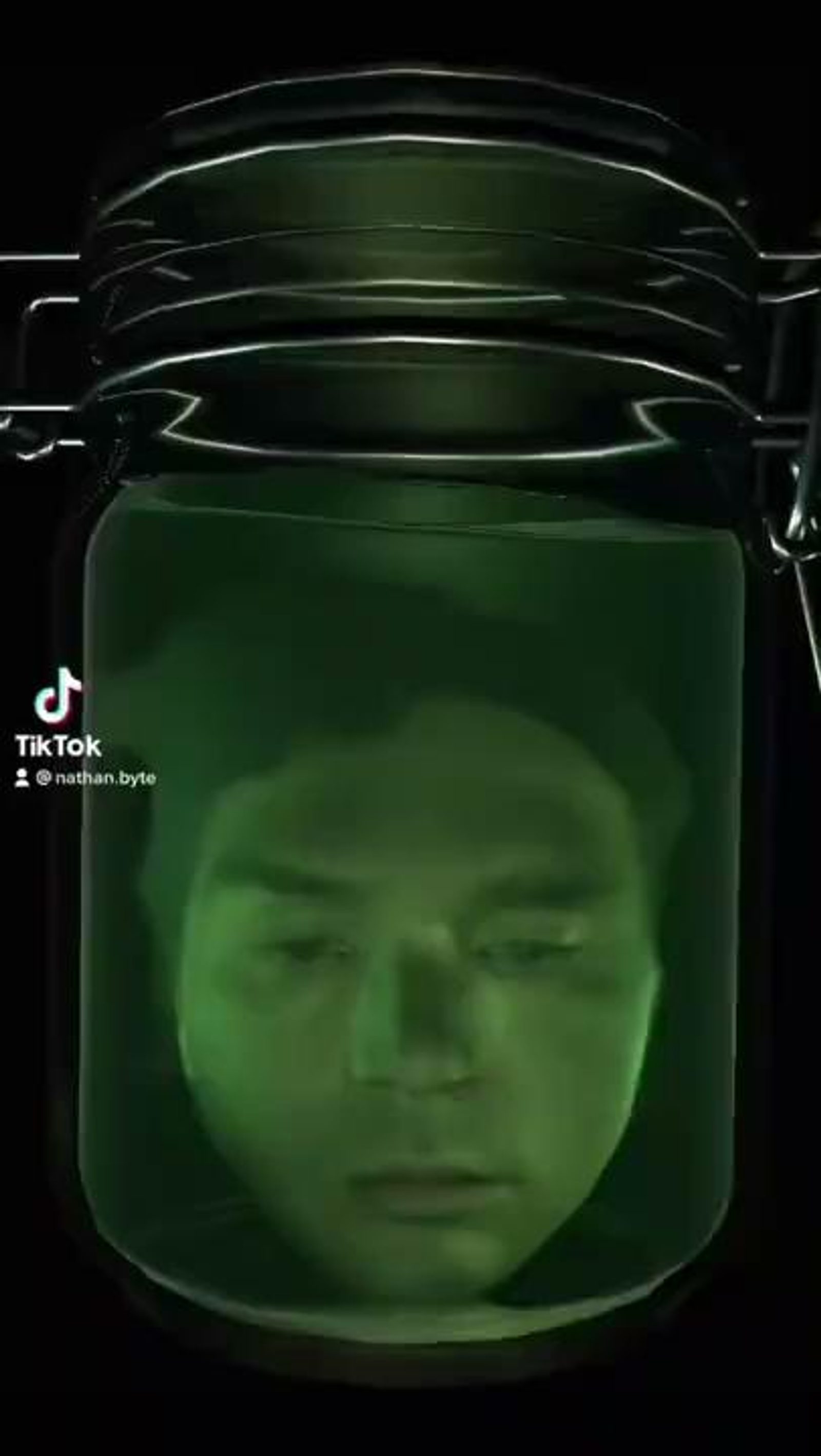 Head in a Jar effect: a face floating in a green preserving jar